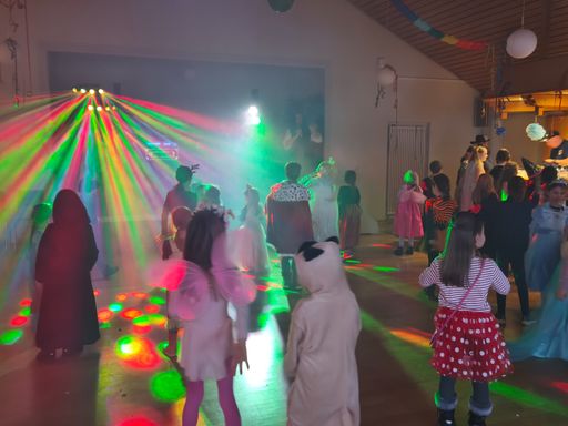 tanzende Kinder in Kostümen im bunten Licht