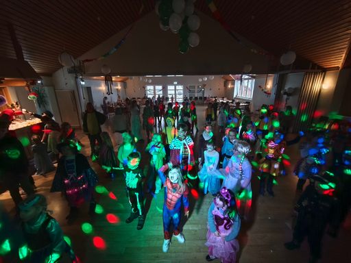 tanzende Kinder in Kostümen im bunten Licht