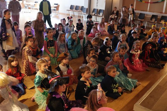 Kinder in Kostümen lauschen gespannt
